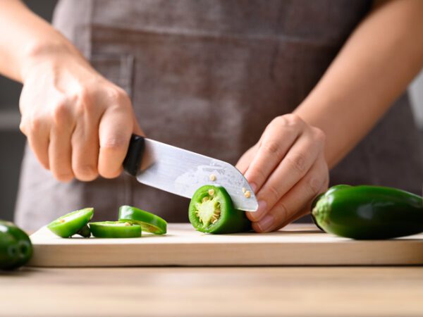Fresh green Jalapeno chili cutting on wooden board